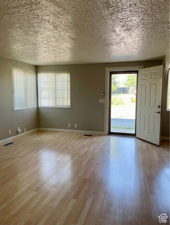 Entrance foyer with light wood-style flooring and a textured ceiling