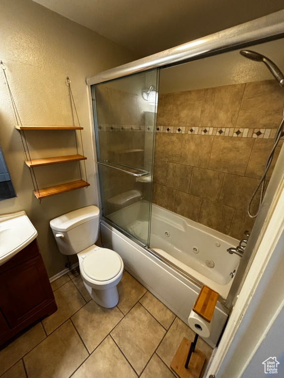 Full bath featuring tile patterned floors, a combined bath / shower with jetted tub, vanity, and a textured wall