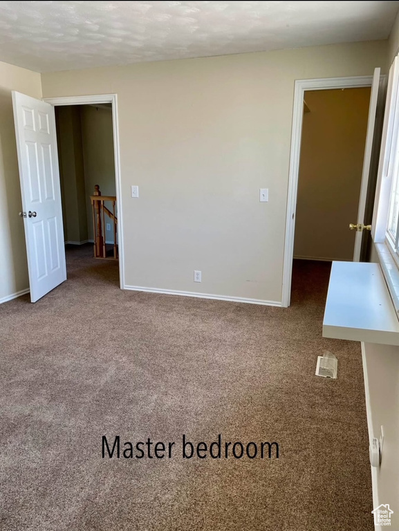 Carpeted spare room with baseboards