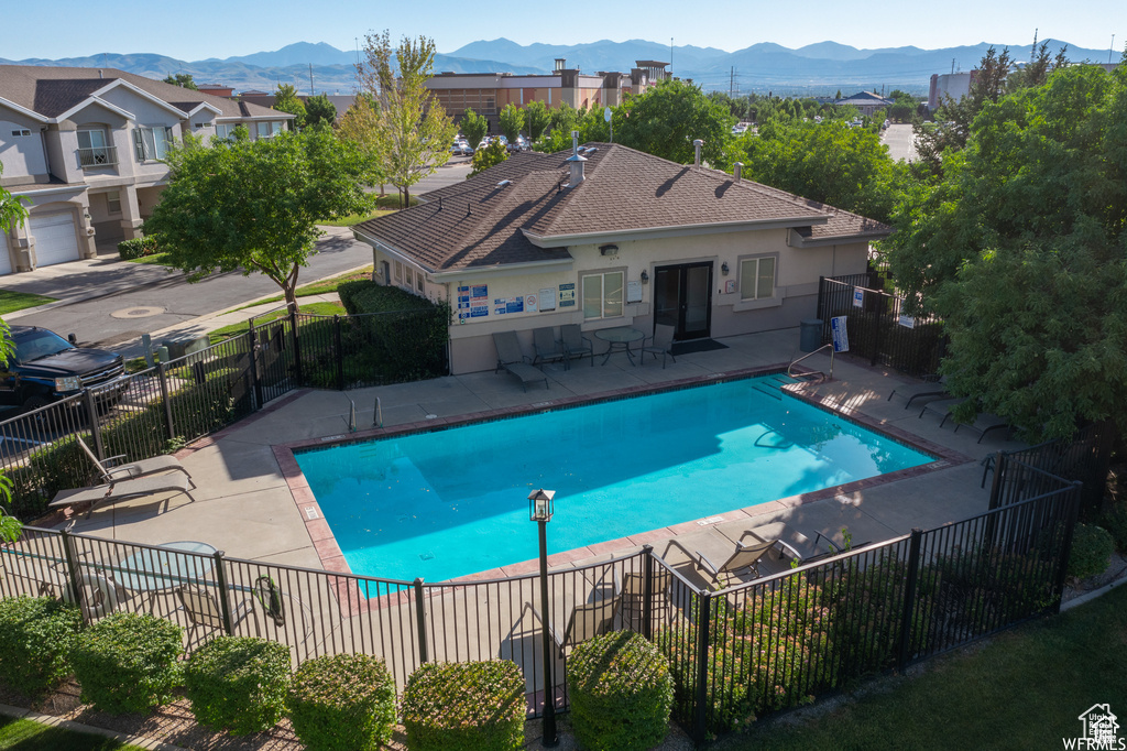 Community pool featuring a mountain view and a patio area