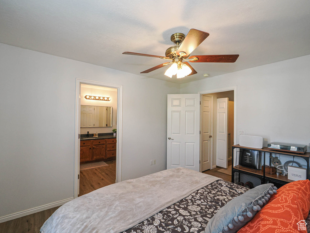 Bedroom featuring dark wood-style flooring, connected bathroom, and ceiling fan
