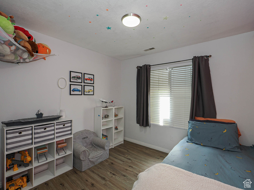 Bedroom with wood finished floors and baseboards