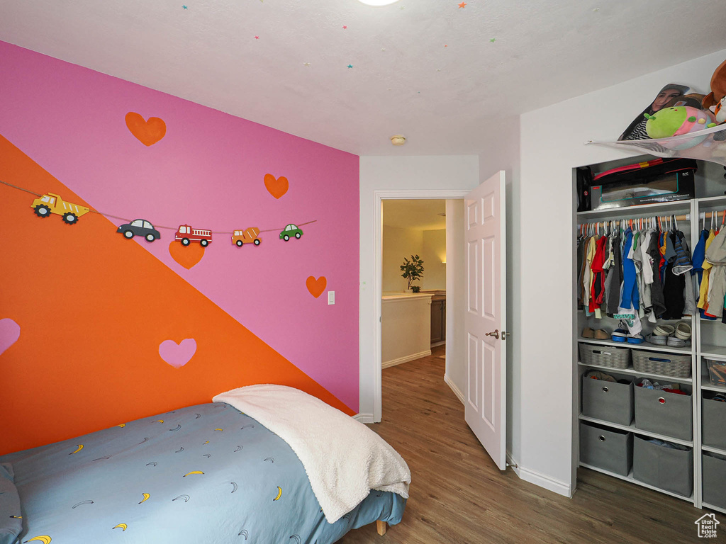 Bedroom featuring wood finished floors and a closet