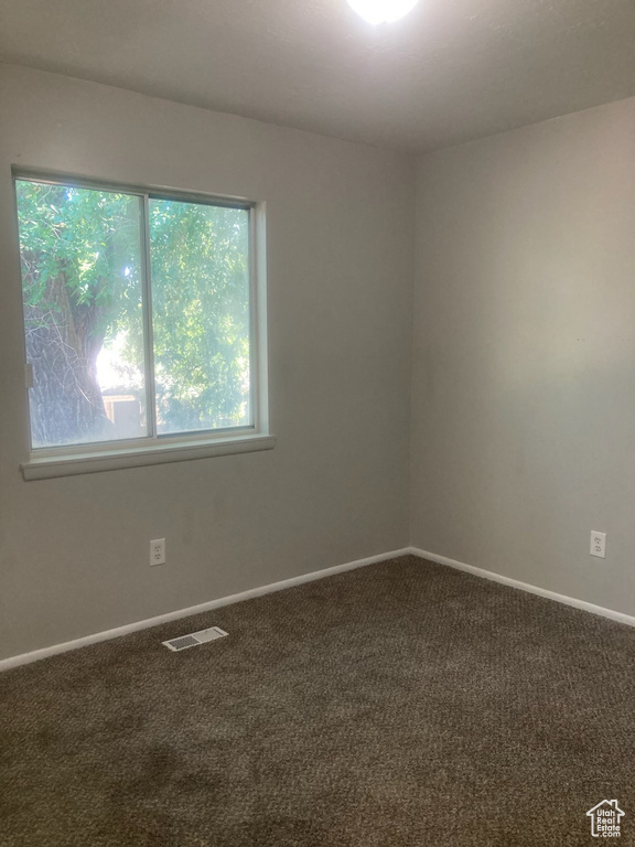 Carpeted empty room featuring baseboards