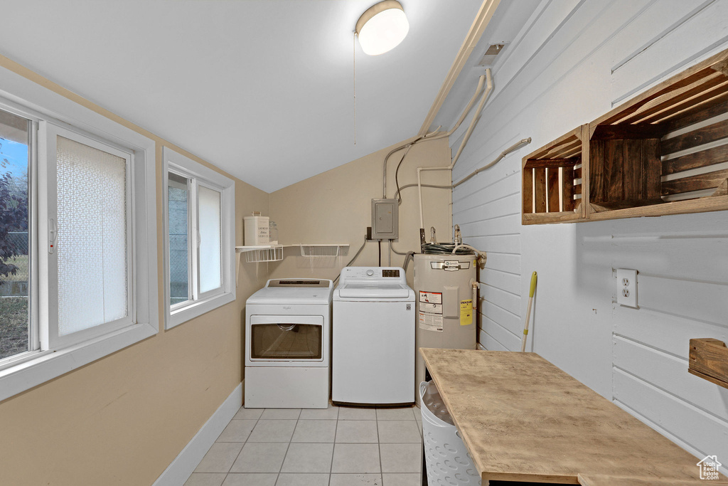 Laundry room with independent washer and dryer, plenty of natural light, light tile patterned flooring, and electric water heater