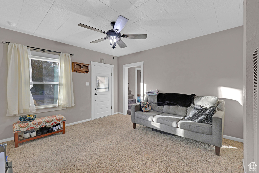 Living room featuring carpet flooring and a ceiling fan