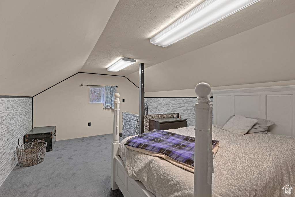 Bedroom with carpet floors and lofted ceiling