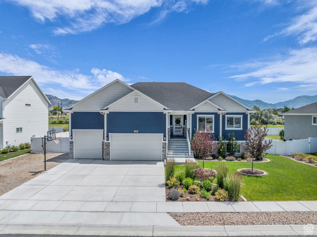 View of front of home featuring a mountain view, a garage, and concrete driveway