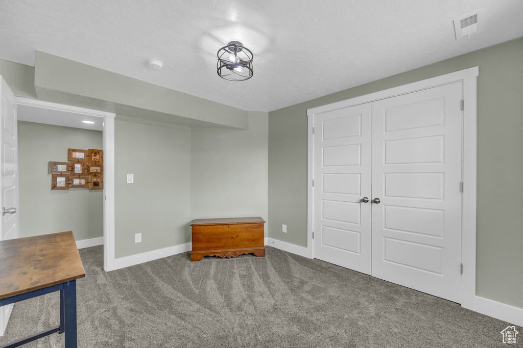 Carpeted bedroom with baseboards and a closet