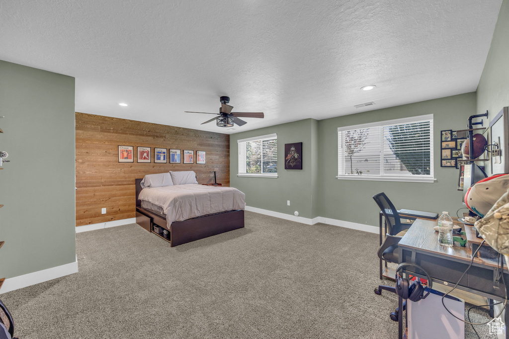 Bedroom featuring wooden walls, a textured ceiling, carpet floors, recessed lighting, and ceiling fan