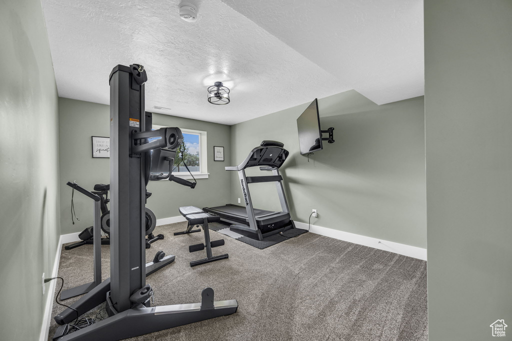 Workout room featuring baseboards and a textured ceiling