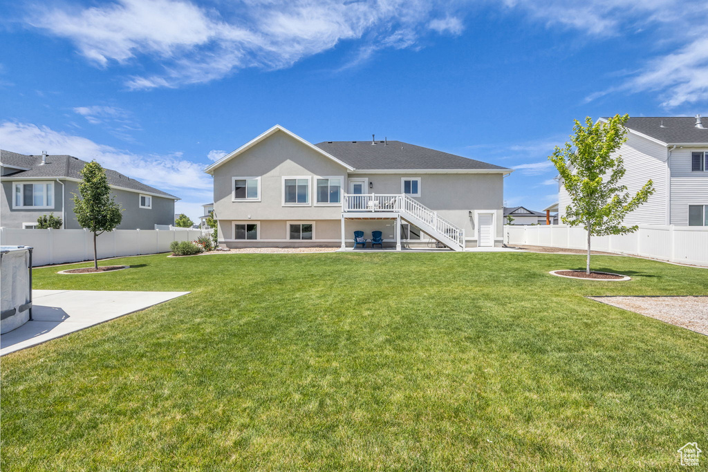 Back of property with a fenced backyard, stairs, stucco siding, and a patio area