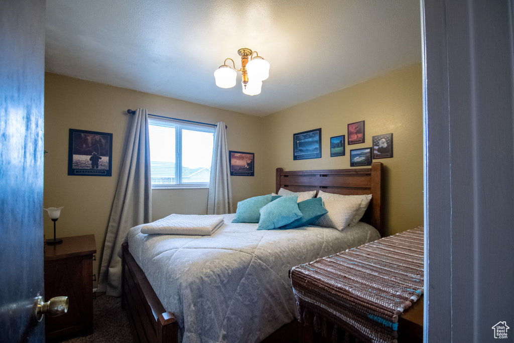 Bedroom with a chandelier and carpet