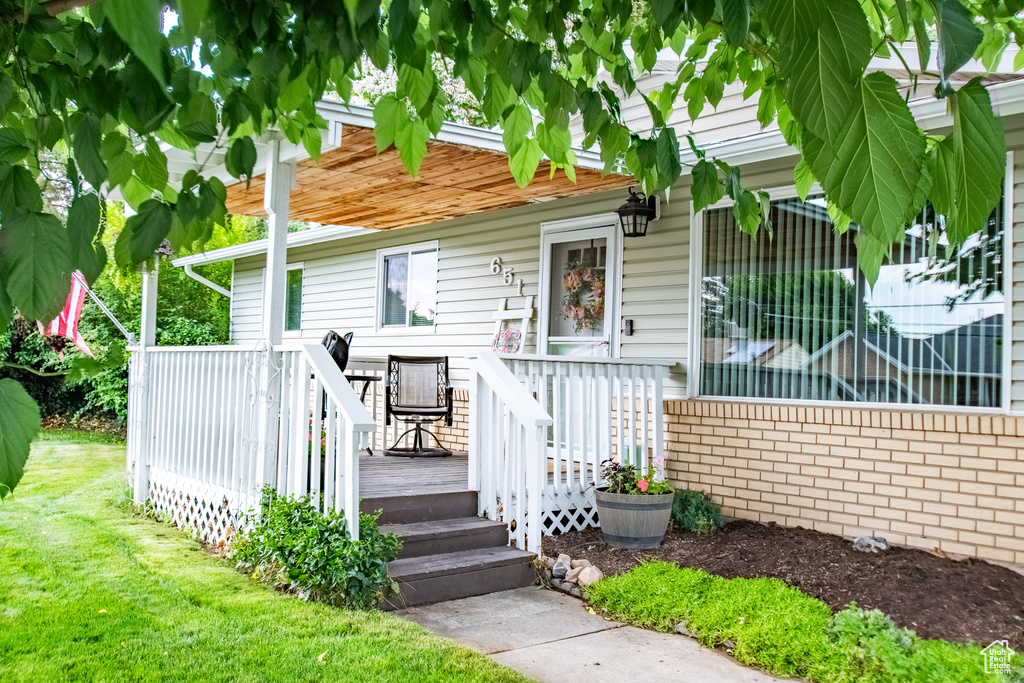 View of front facade featuring a deck and a front lawn