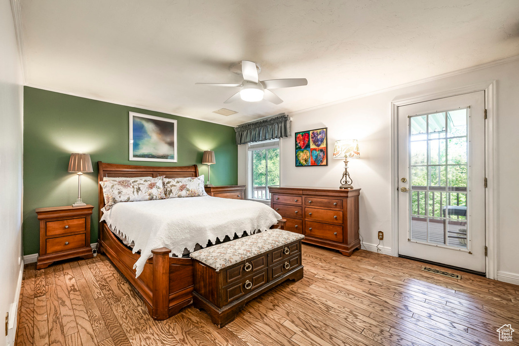 Bedroom with access to outside, light wood-type flooring, a ceiling fan, and ornamental molding