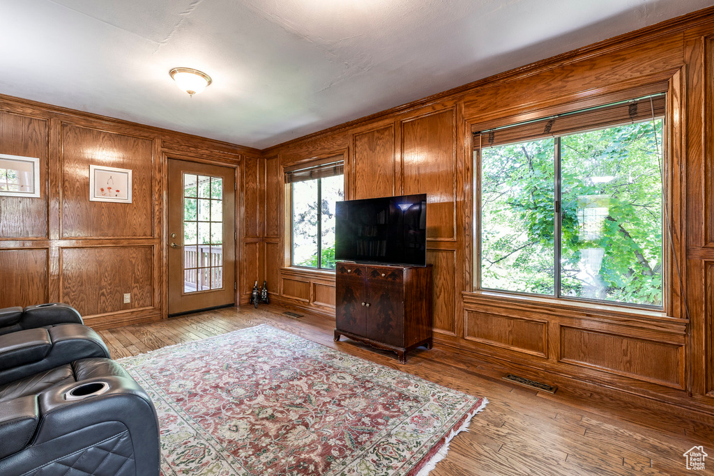 Living room with hardwood / wood-style flooring and wood walls