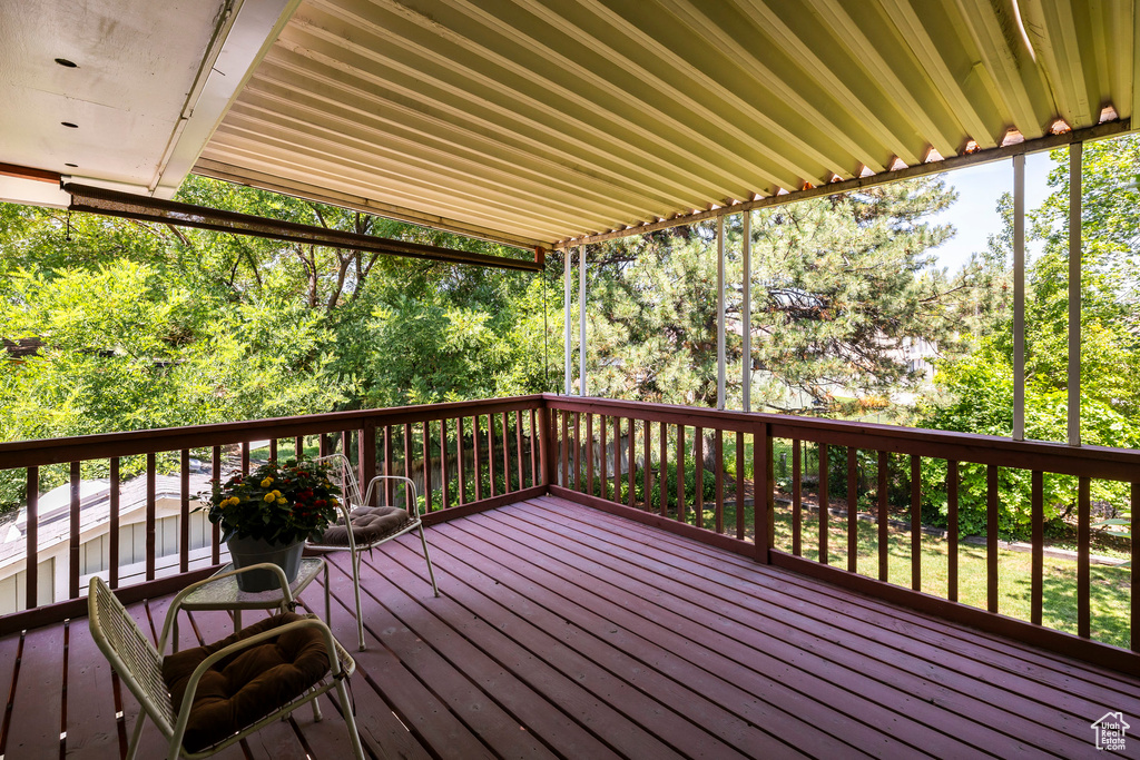 Wooden terrace featuring view of wooded area