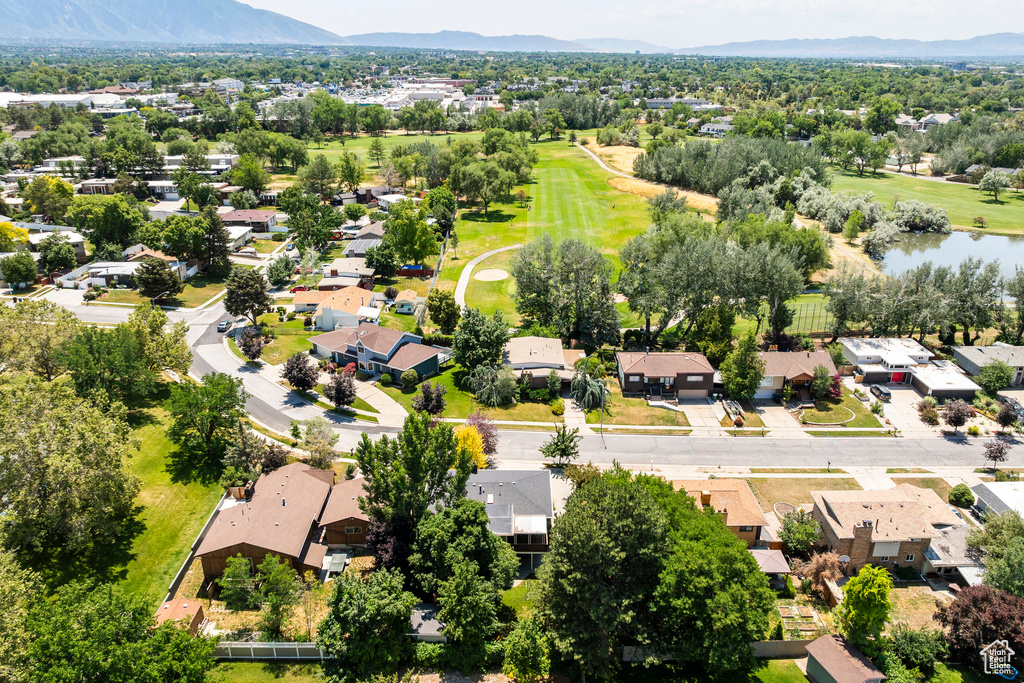 Aerial perspective of suburban area featuring a golf club and a water and mountain view