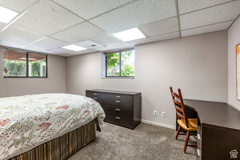 Bedroom with a paneled ceiling, carpet floors, and an office area
