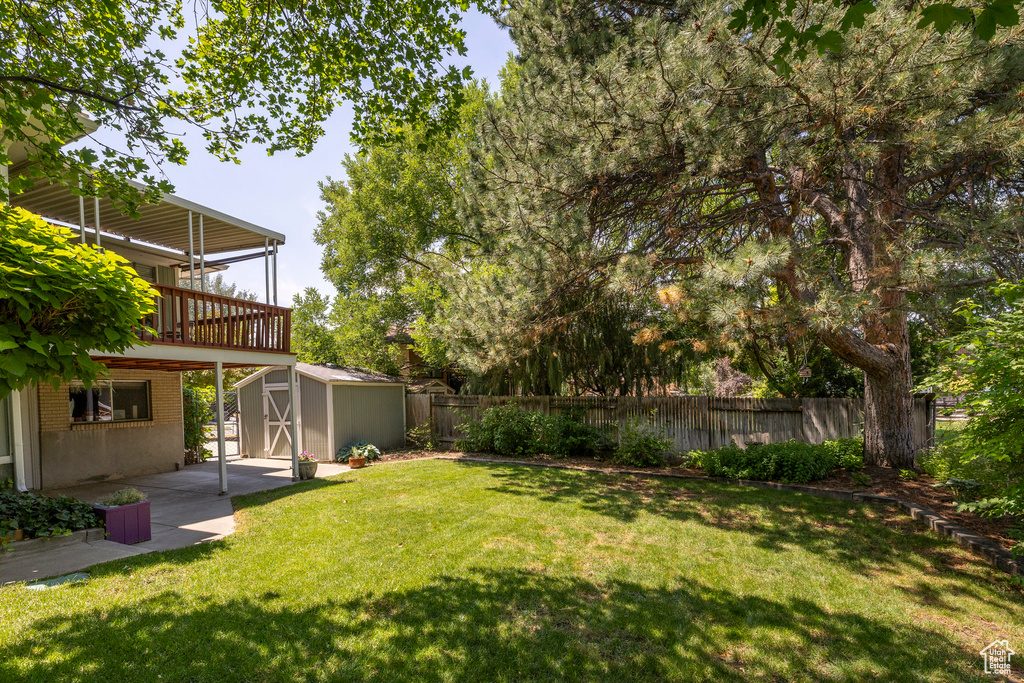 Fenced backyard with a shed, a patio area, and a deck