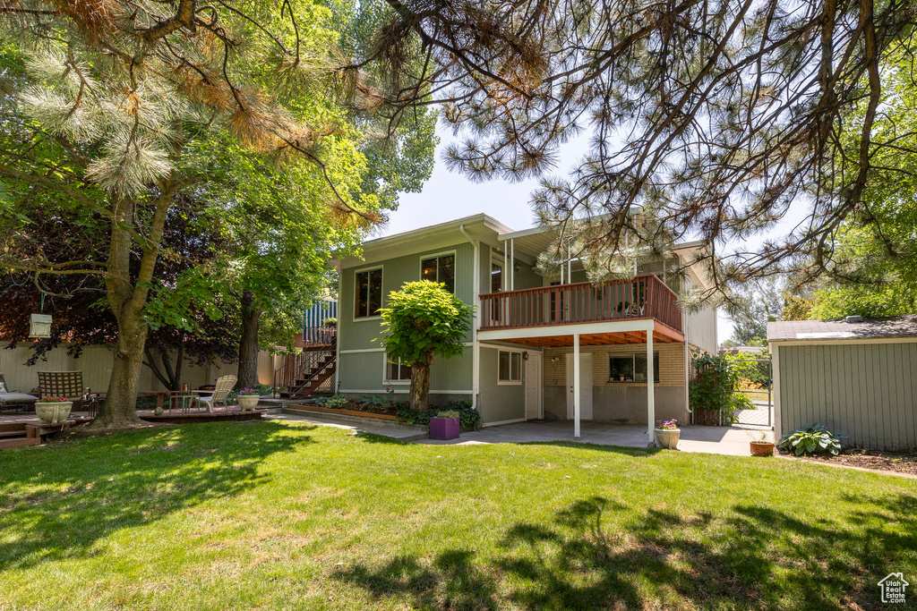 Back of property with a patio area, stairway, a yard, and a wooden deck