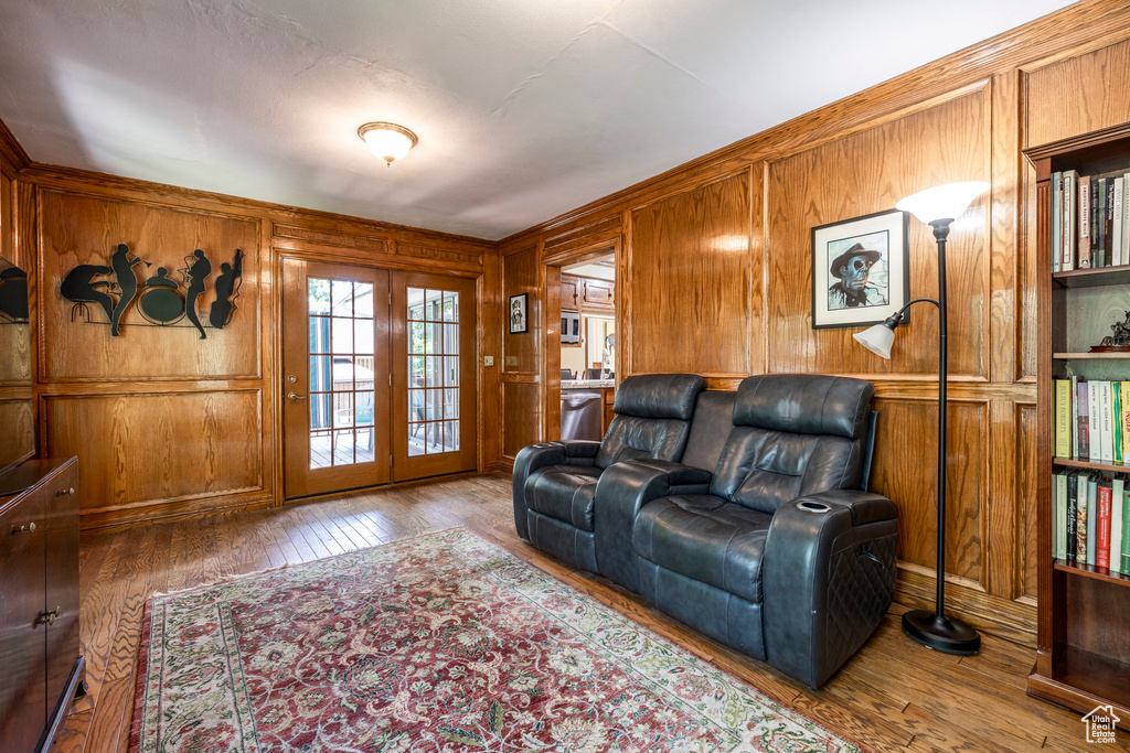 Living room with wood walls, hardwood / wood-style flooring, and french doors
