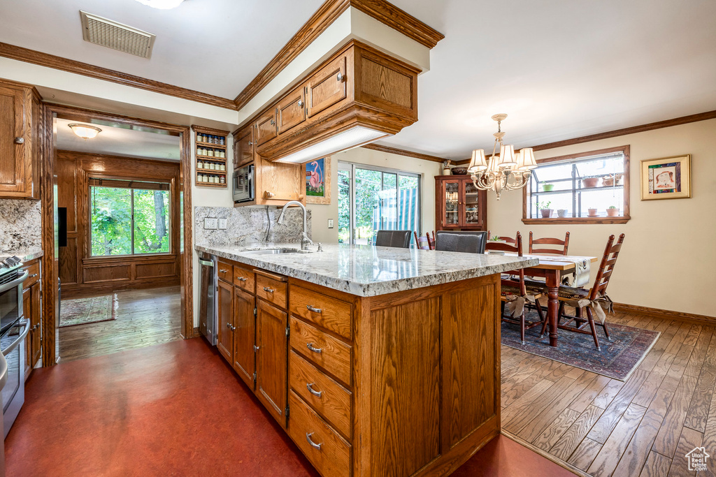 Kitchen with plenty of natural light, tasteful backsplash, stainless steel appliances, and crown molding
