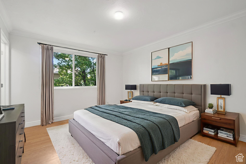 Bedroom featuring light wood-style floors and ornamental molding