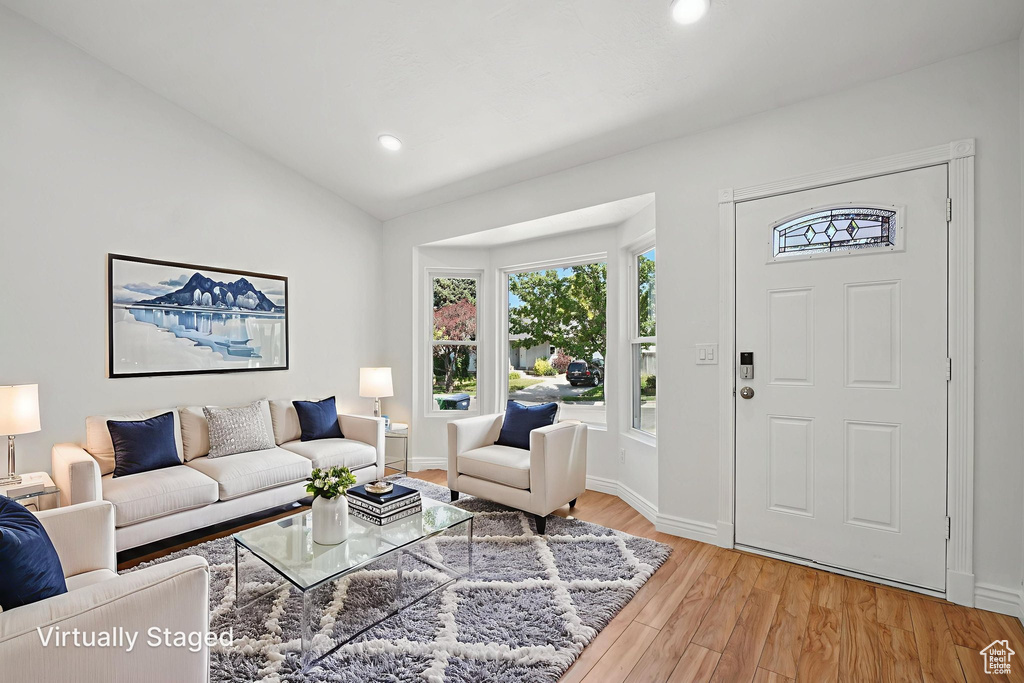 Living area featuring light wood finished floors, recessed lighting, and lofted ceiling