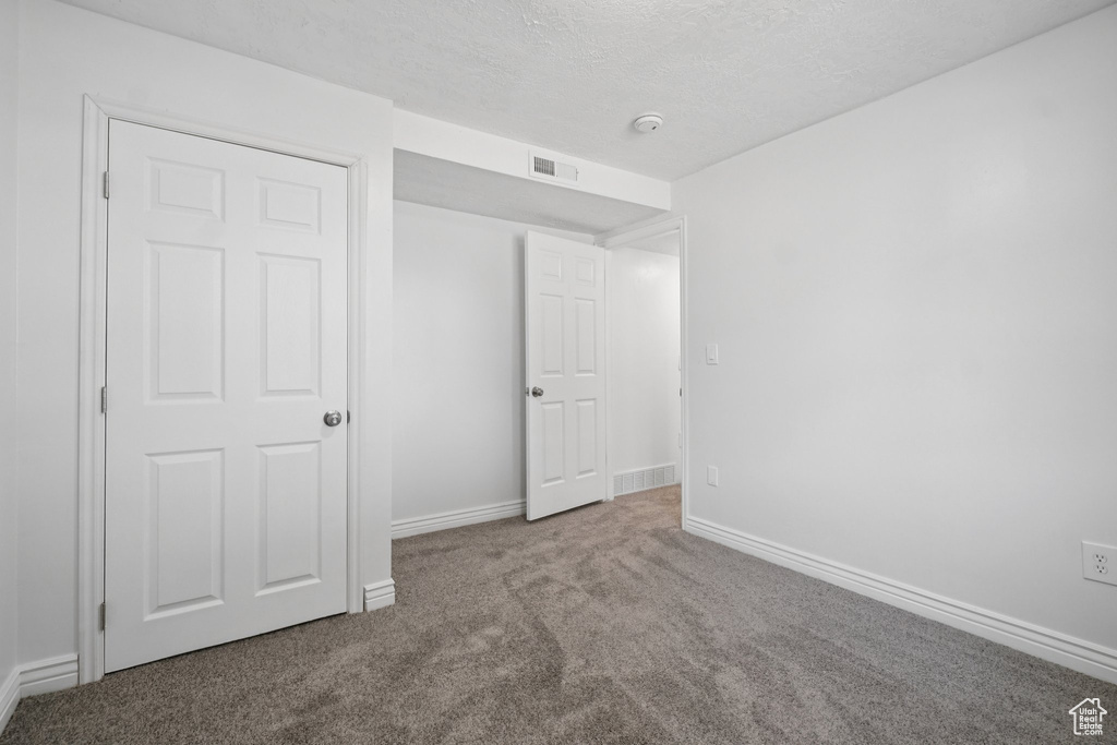 Unfurnished bedroom with carpet flooring and a textured ceiling