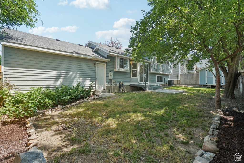 View of yard with entry steps and a storage unit