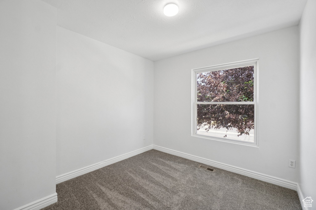 Carpeted empty room with baseboards