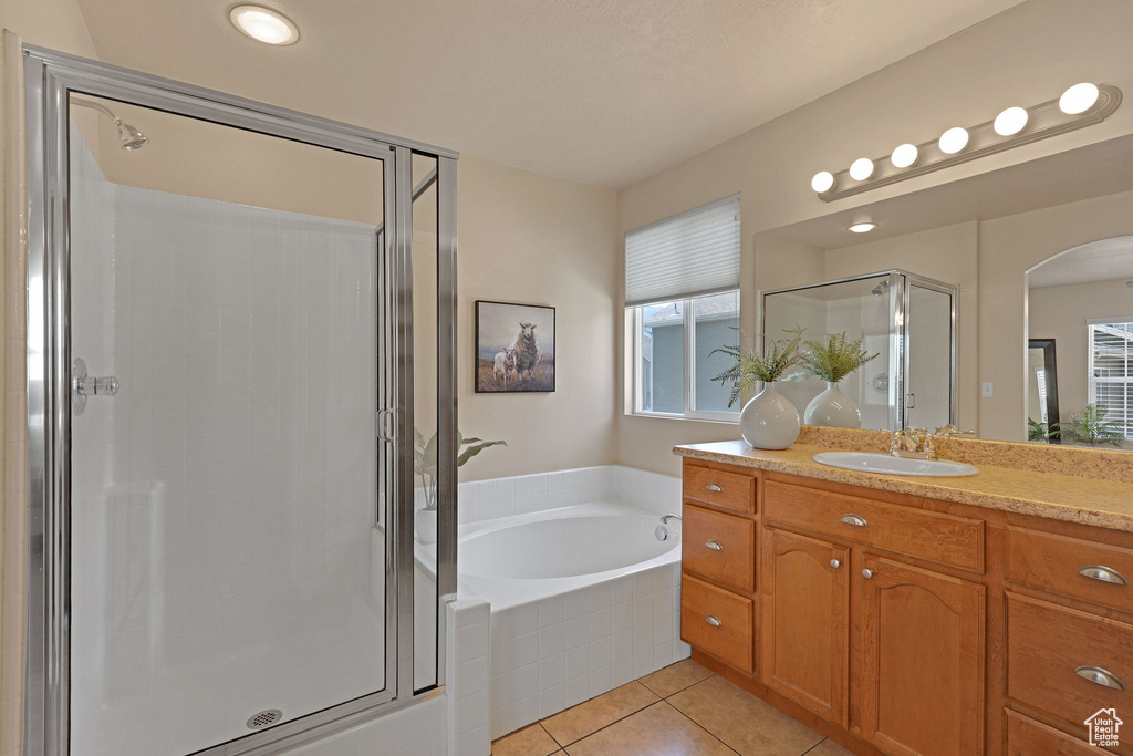 Full bathroom with vanity, a stall shower, tile patterned floors, and a bath