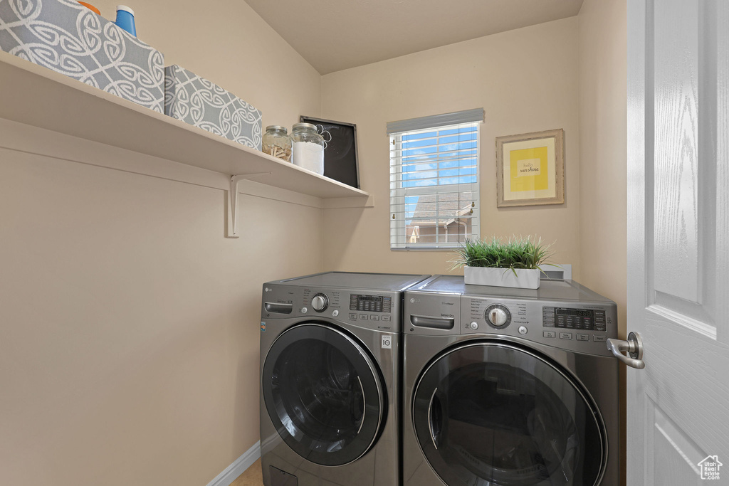 Laundry area with washing machine and clothes dryer and baseboards