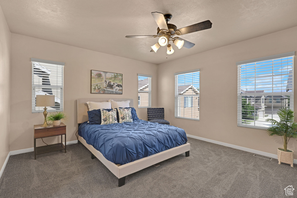 Carpeted bedroom featuring baseboards and ceiling fan