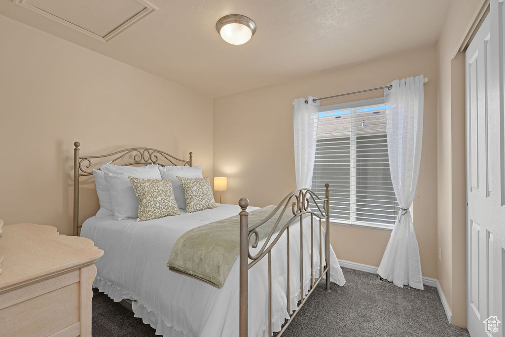 Carpeted bedroom featuring a closet and baseboards