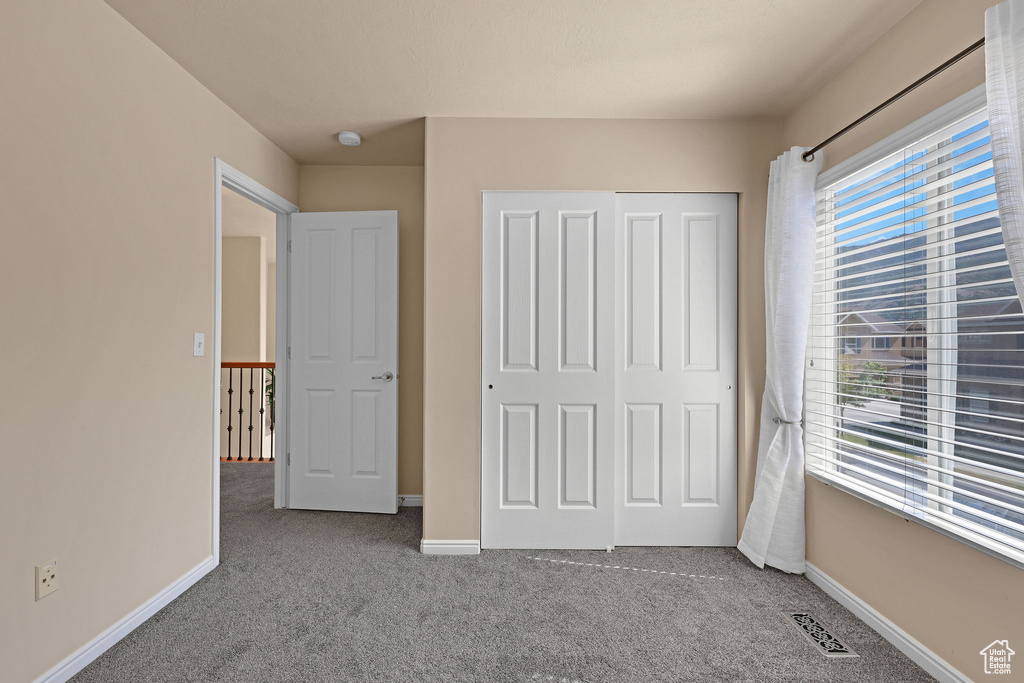 Unfurnished bedroom featuring carpet and a closet