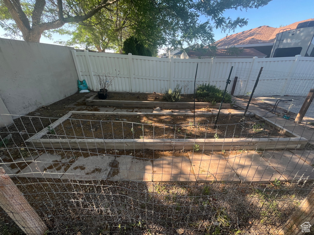 Fenced backyard featuring a vegetable garden and a mountain view