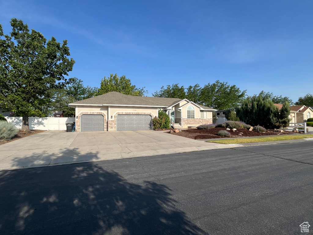 Ranch-style home with a garage, driveway, and stucco siding