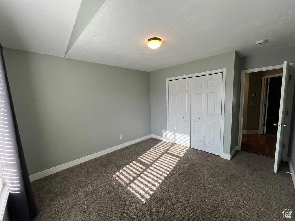 Unfurnished bedroom with carpet and a closet