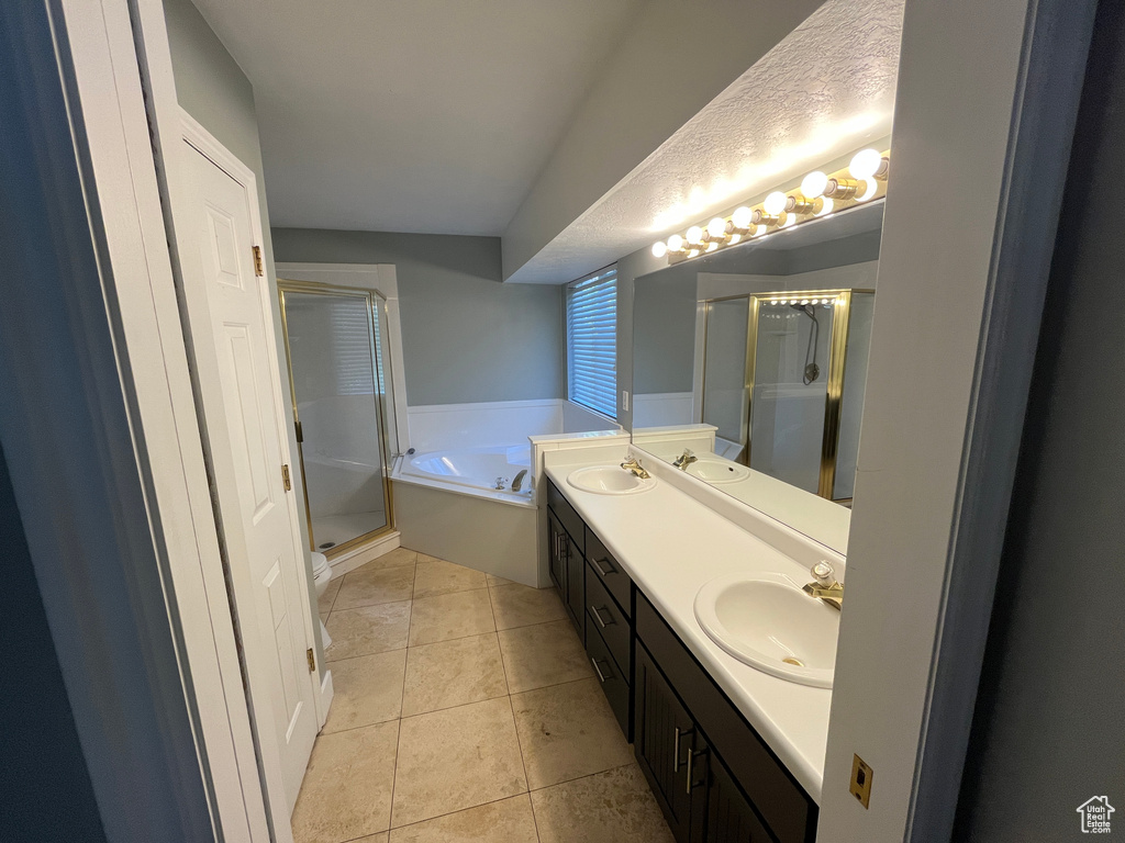 Full bath featuring a shower stall, double vanity, a garden tub, and tile patterned floors