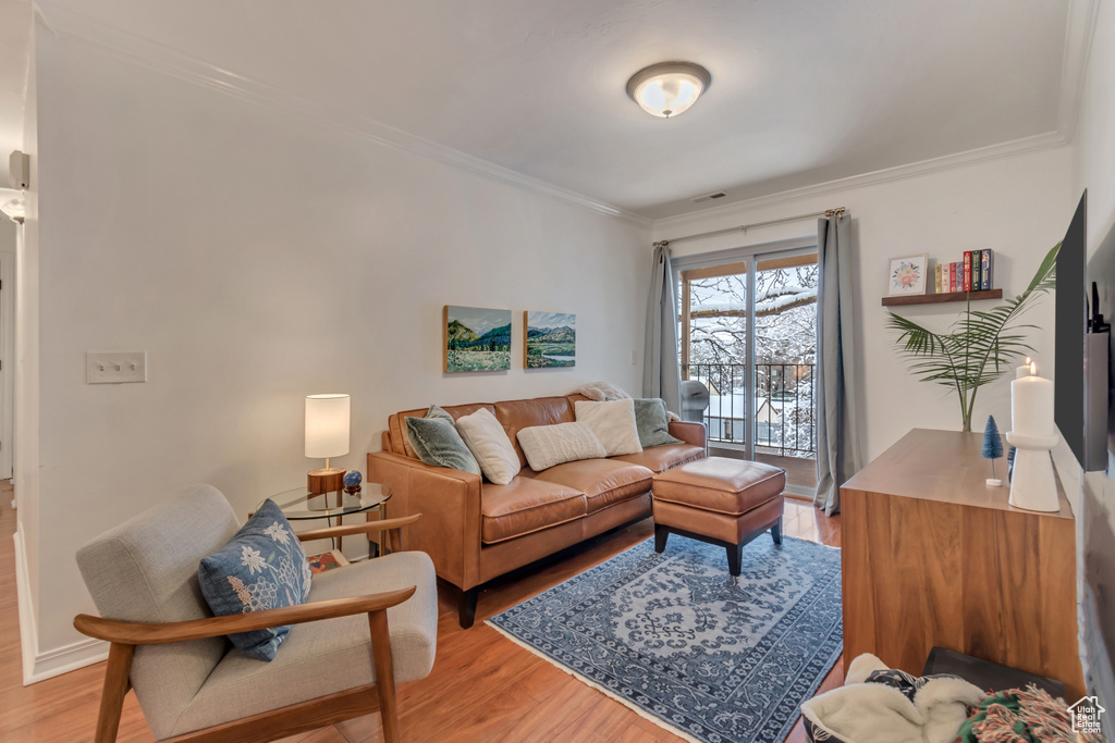 Living area featuring crown molding and light wood-type flooring