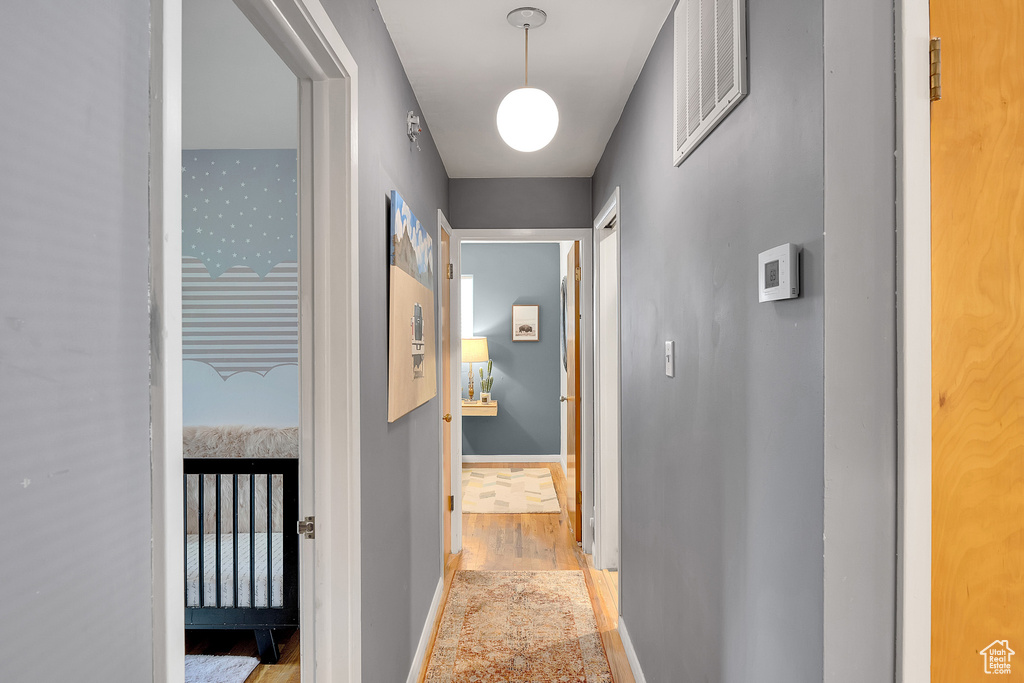 Hallway featuring light wood-type flooring and baseboards