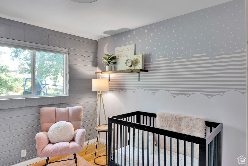 Bedroom featuring a crib and wood finished floors