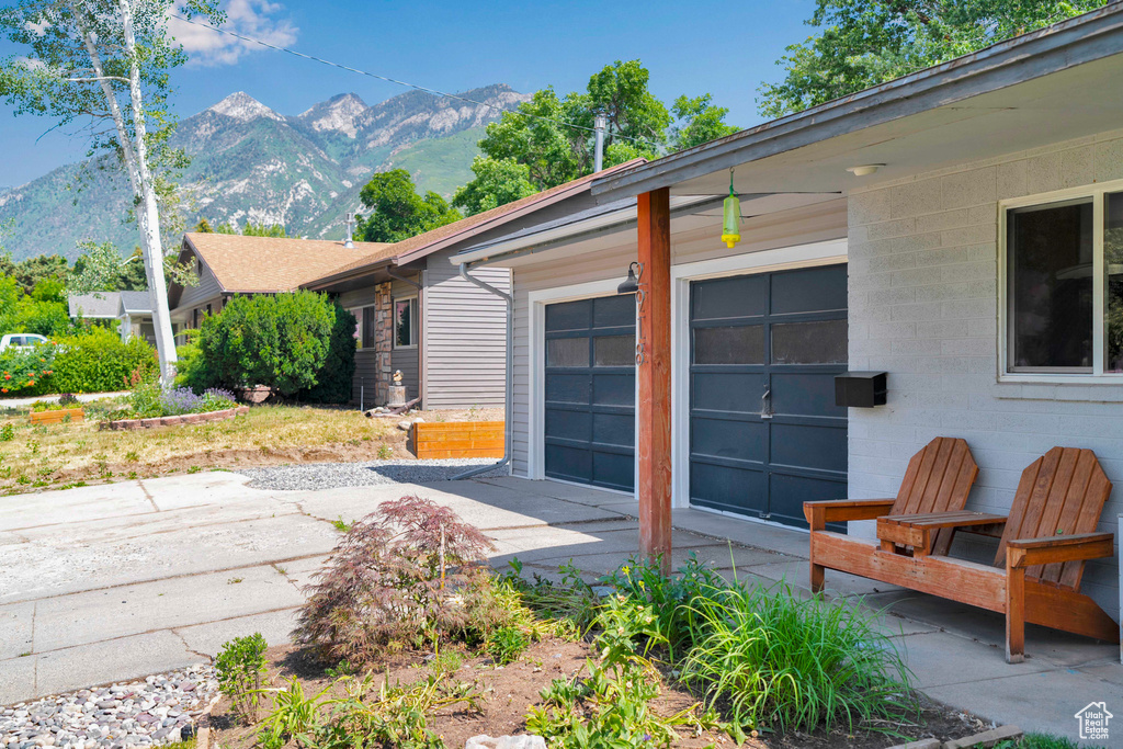 View of side of property with driveway, a mountain view, and a garage