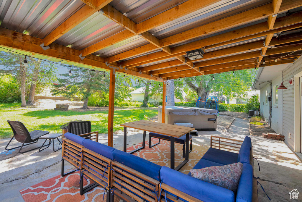 View of patio / terrace with a hot tub and an outdoor hangout area