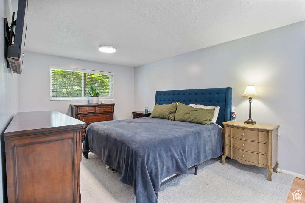 Bedroom featuring a textured ceiling and light wood finished floors