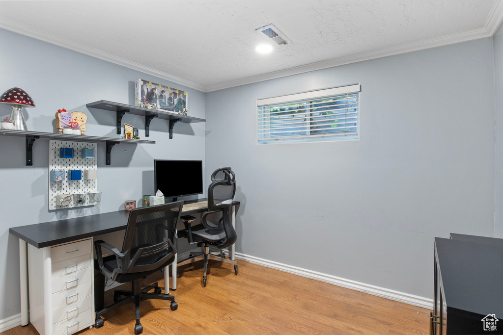Office with ornamental molding and light wood finished floors