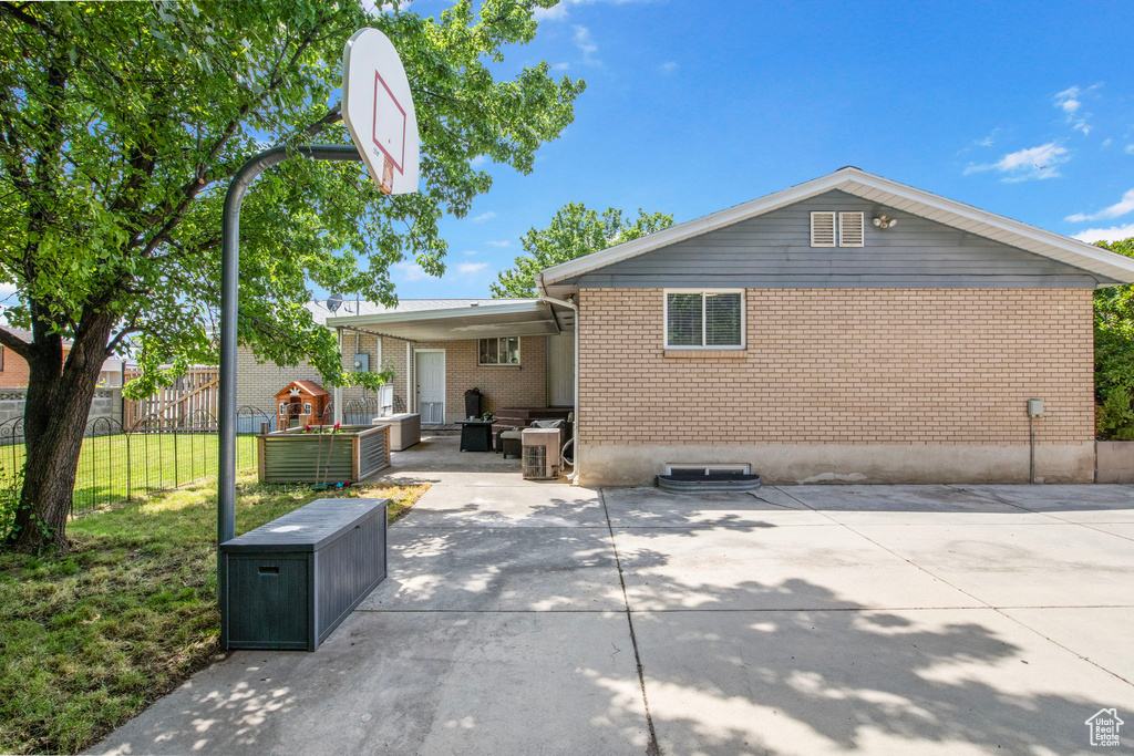 Rear view of property featuring brick siding and a patio area