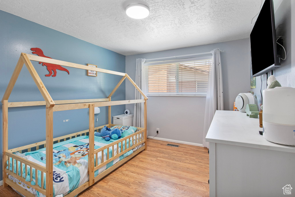 Bedroom featuring a textured ceiling and wood finished floors